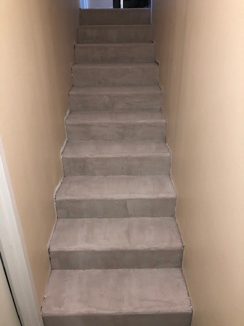 Le même escalier terminé : marches et contremarches d'un gris uniforme d'une volée à l'autre.